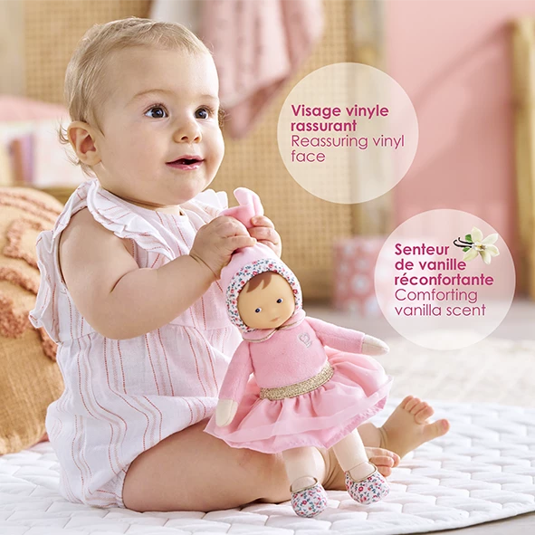 Bébé qui tient Doudou Miss Ballerine Rose Grenadine par son bonnet