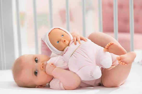 Bébé sur le dos dans un lit avec Doudou Babipouce Pays des Rêves