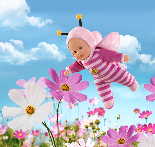 Poupon Pti'Coeur Abeille en train de voler dans un décor de fleurs
