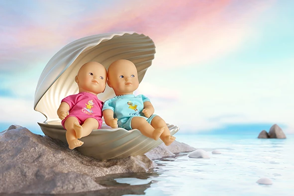 Poupon Mini Bain Bleu et Rose dans un coquillage au bord de l'eau