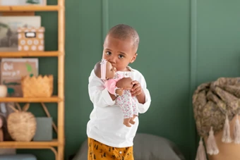 Bébé qui fait un bisou au poupon